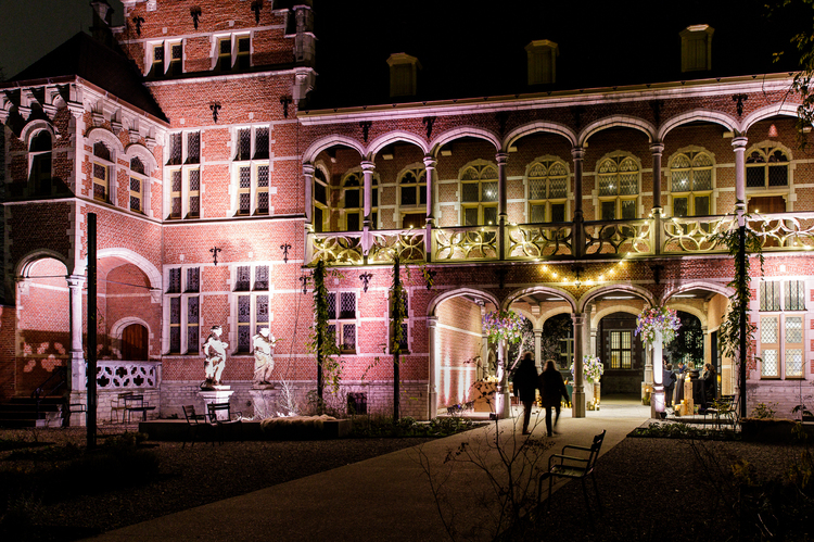 Een nachtbeeld van het stadspaleis, vrolijk verlicht met kerstlampjes.