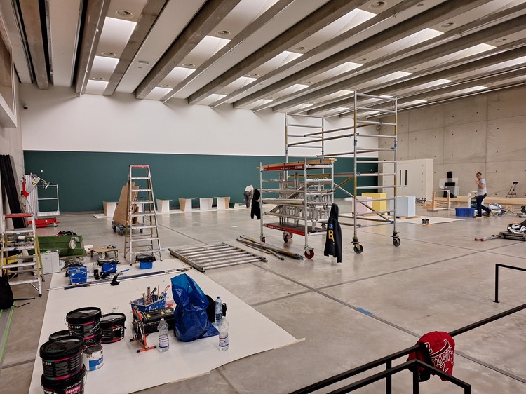 Een grote museumzaal is in opbouw.