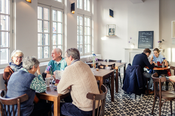 Un groupe de personnes est assis dans un caf&eacute;.